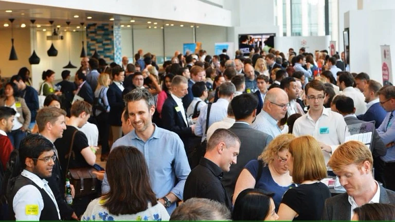 Profesionales de negocios locales estableciendo relaciones en evento de networking presencial