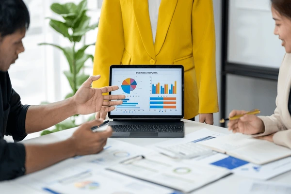 Profesional analizando gráficos de autoridad web en portátil con notas manuscritas