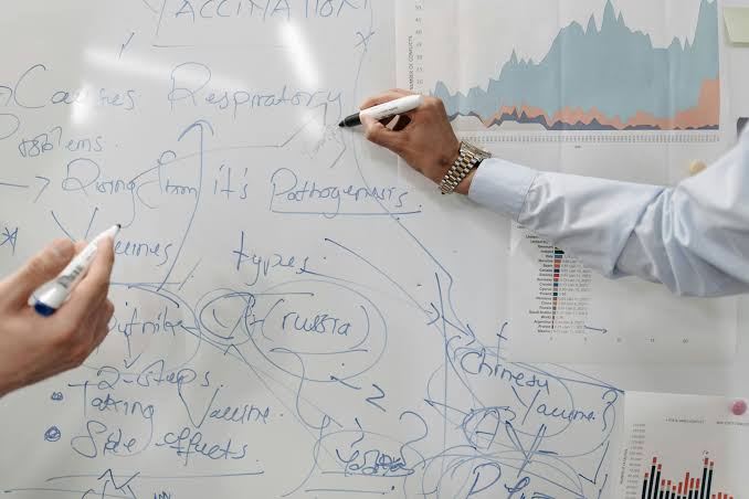 Equipo SEO planificando estrategia híbrida sobre pizarra con diagramas y flujos