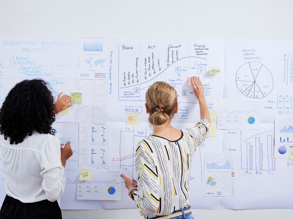 Equipo de marketing digital planificando estrategia en pizarra con métricas