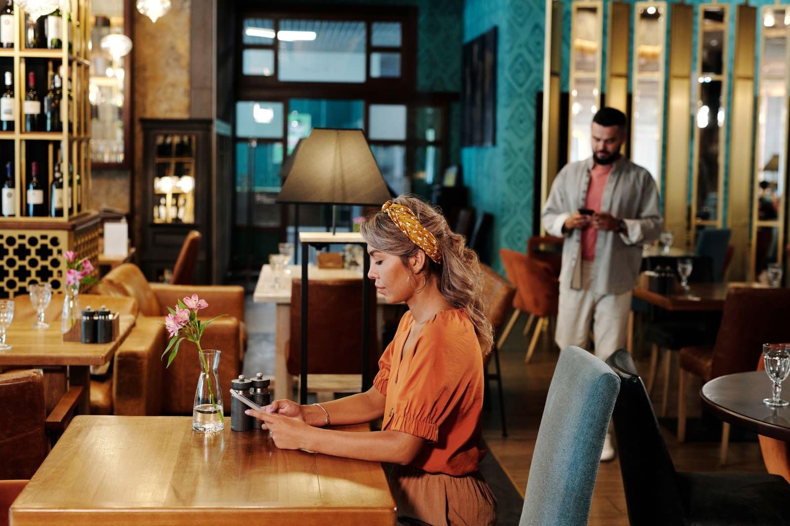 Hostelero consultando el móvil en un comedor vacío antes del servicio