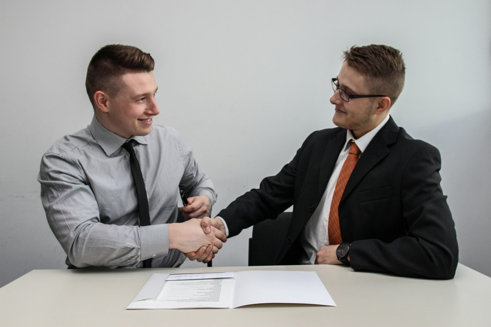Acuerdo profesional entre dos personas durante una negociación editorial