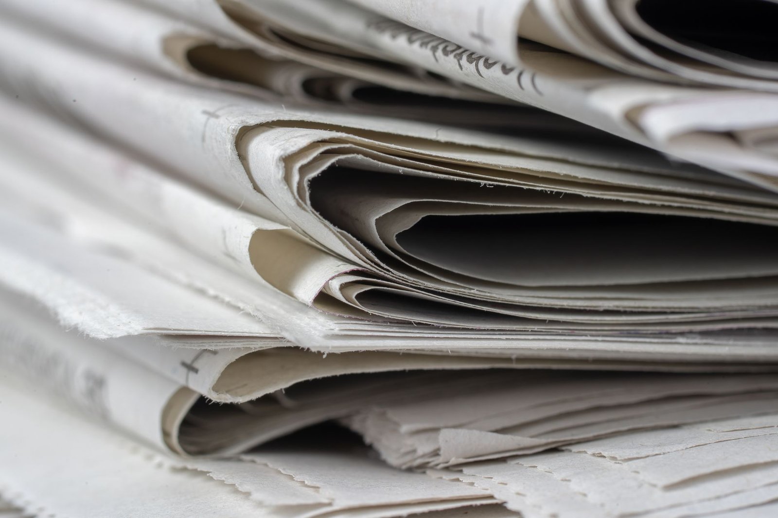 Ejemplares de prensa provincial apilados como soporte de menciones editoriales
