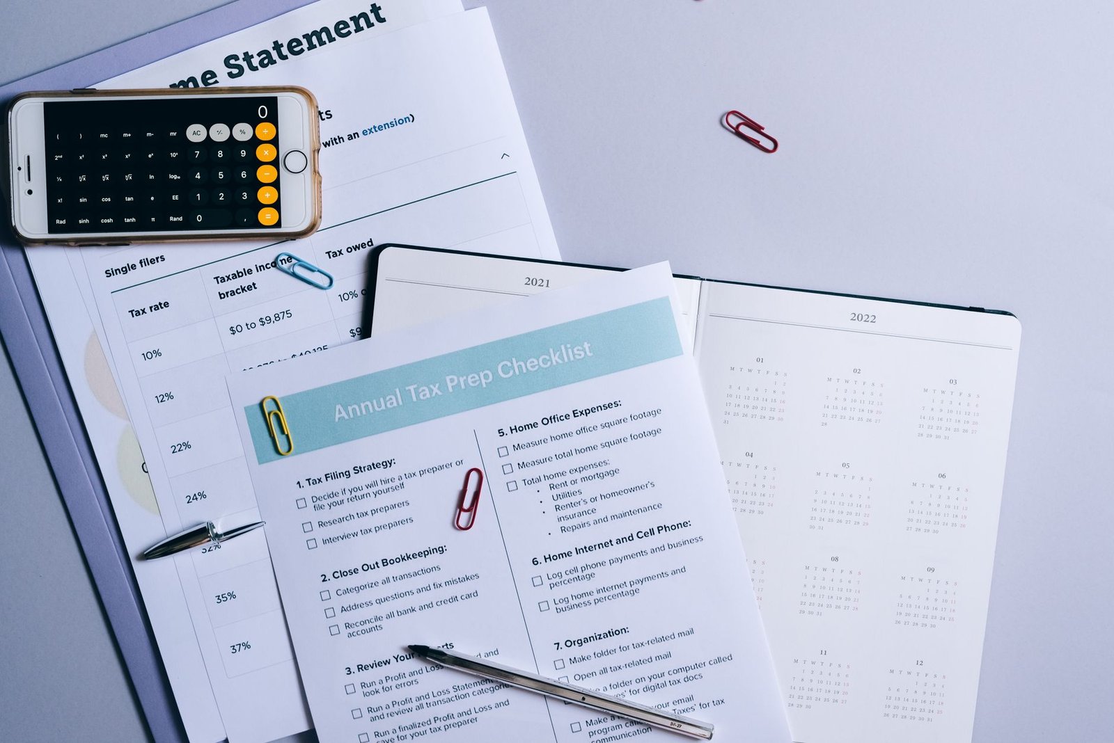 Calendario trimestral con marcas de color y libreta con lista de tareas de prospección